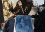 Anti-Gaddafi rebels tear a picture of Libyan leader Muammar Gaddafi at a checkpoint they just took over near the oil facility of Ras Lanuf